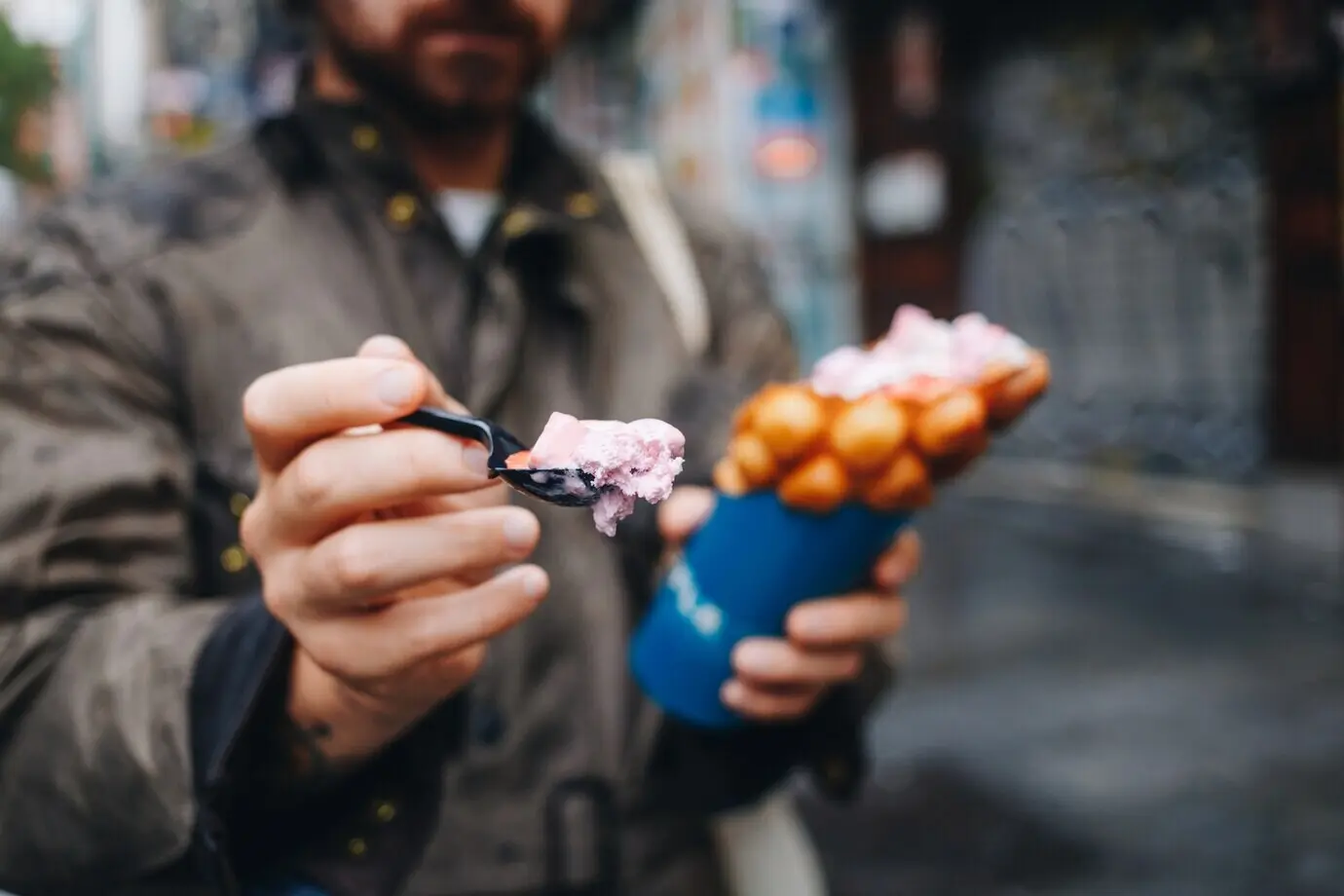A man holds a bubble waffle from a street food truck.